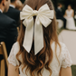 Beatrice Bow Barrette with a pink satin drawstring bag.