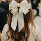 Beatrice Bow Barrette with a pink satin drawstring bag.