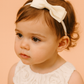 Posie Cream Headband with a pink satin drawstring bag.
