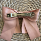 Rose Bow Barrette (Ages 3 upwards) with a pink satin drawstring bag.